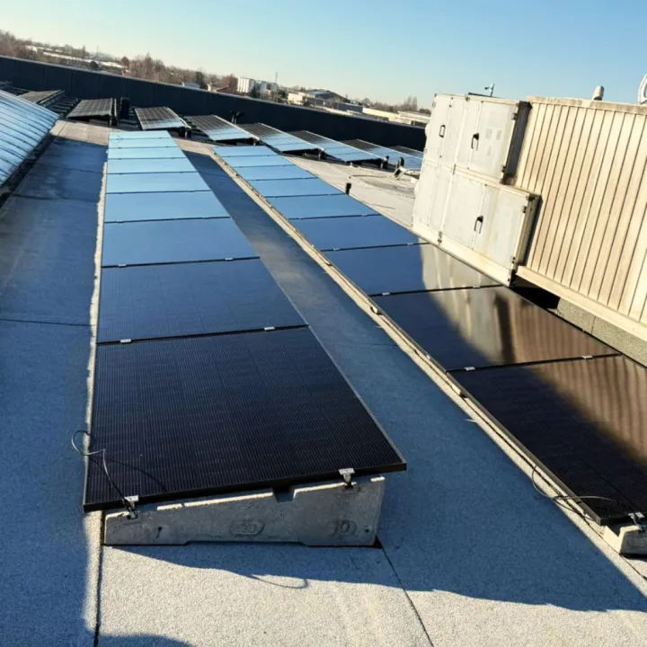 Impianto fotovoltaico aziendale su tetto piano realizzato in Friuli-Venezia Giulia con supporti in cemento.